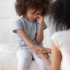 Purchased - Parents comforting a child with growing pains